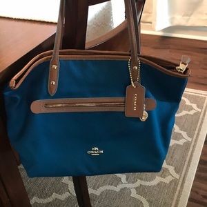 Blue Coach bag. Over the shoulder.